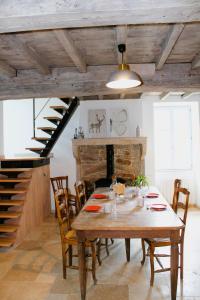LE CLOS DES PIERRES ROUGES في Burgy: غرفة طعام مع طاولة خشبية ومدفأة