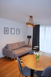 sala de estar con sofá y mesa en Lighter Apartment, en Gdansk
