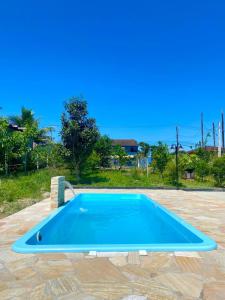 een groot blauw zwembad in een tuin bij Apartamento em chácara próximo as praias com piscina e quiosque com internet in São Francisco do Sul