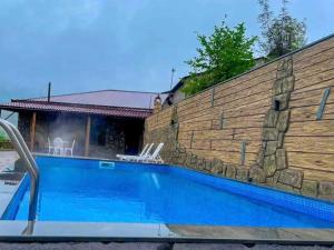 a swimming pool in front of a brick wall at Kamar Hotel Ijevan in Ijevan