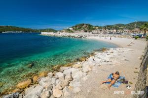 een vrouw op een strand bij het water bij Casa di Pietro in Porto Azzurro