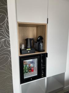 a small tv in a cabinet with drinks in it at Kamienica no 111a in Warsaw