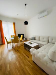 a living room with a white couch and a table at Apartment DORA in Cetinje