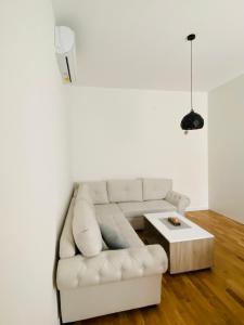 a living room with a white couch and a coffee table at Apartment DORA in Cetinje