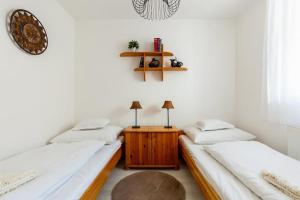een kamer met 2 bedden en een houten tafel bij Flat White Apartment in Boedapest
