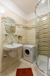 een badkamer met een wastafel en een wasmachine bij Flat White Apartment in Boedapest