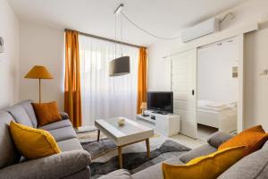 een woonkamer met een bank en een tv bij Flat White Apartment in Boedapest