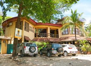 una casa con auto parcheggiate di fronte di Hotel Boruca Tamarindo a Tamarindo