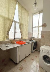 OLTREMARE casa per vacanze con terrazzo في كازارانو: مطبخ مع مغسلة وغسالة ملابس