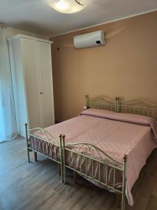 1 dormitorio con 1 cama con manta rosa en Stanza Lillina en San Benedetto del Tronto