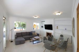 a living room with a couch and a table at Villa Beach Alcudia, lovely house with jacuzzi in Alcudia