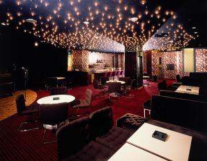 a room with chairs and tables and lights on the ceiling at Entaijiso in Kurobe