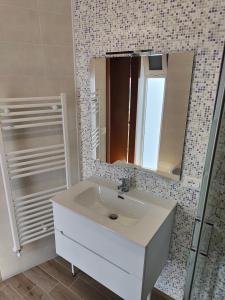 W łazience znajduje się umywalka i lustro. w obiekcie Stanza Lillina w mieście San Benedetto del Tronto