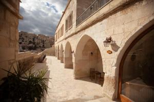 an alley with arches on a building with a table at Narcissos Cave Hotel in Urgup
