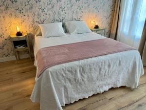 a bedroom with a bed with a white comforter and two lamps at Casa da Fonte in Ourense