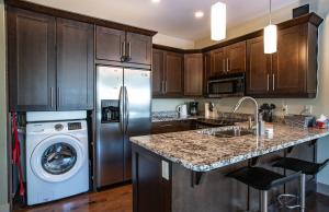a kitchen with a stainless steel refrigerator and a dishwasher at Selkirk Snug by Revelstoke Vacations in Revelstoke