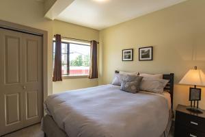 a bedroom with a large bed and a window at Selkirk Snug by Revelstoke Vacations in Revelstoke
