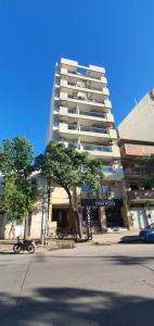 a tall building with a tree in front of it at Departamento 1 dormitorio, Saenz Peña. in Santiago del Estero