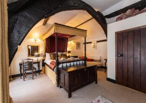 a bedroom with a canopy bed with a desk and a table at The Oval in Dunster