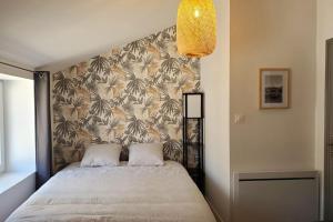 a bedroom with a large bed with a wall at L'IDYLLE - Studio Cocooning avec Jacuzzi in Mâcon