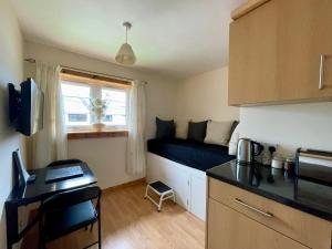 a small apartment with a bed in the corner of a room at Feel at home while you roam in Caol