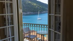 a window with a view of a boat in the water at Linardos Apartments in Asos