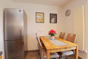 a kitchen with a wooden table and a refrigerator at Ferienwohnung in ruhiger Lage von Zella-Mehlis/ Wohnung Carola in Zella-Mehlis