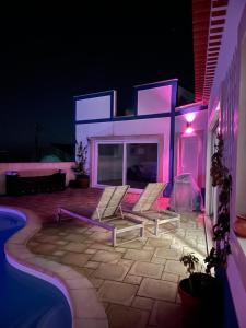 a couple of chairs sitting on a patio at night at Joia da Casa in Sobral