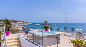 einen Balkon mit Pool und Meerblick in der Unterkunft Le Pativite Luxury Apartments by HDSalento in Santa Maria di Leuca