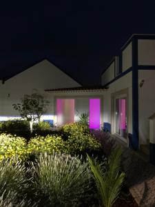 dom z fioletowymi światłami na oknach w nocy w obiekcie Joia da Casa w mieście Sobral