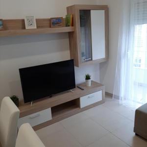a living room with a flat screen tv on a wooden entertainment center at Almada Cristo Rei in Almada