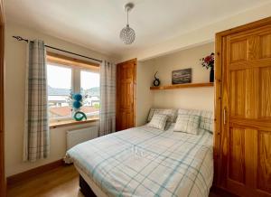 a bedroom with a bed and a window at Failte Mhor in Fort William