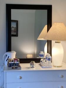 a lamp on top of a dresser with a mirror at LE CHALET de LA LONGERE in Beuvry-Nord
