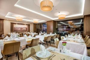 a dining room with white tables and chairs at Nidya Hotel Galataport in Istanbul