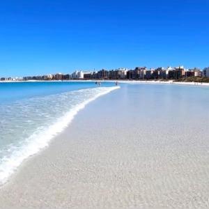 una playa con el océano y edificios de fondo en Cabo Frio - Praia do Forte - Apto 130 m2 na beira da praia, com ar condicionado, en Cabo Frío