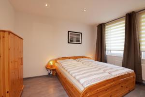 a bedroom with a wooden bed and a window at Ferienwohnung in ruhiger Lage von Zella-Mehlis/ Wohnung Carola in Zella-Mehlis
