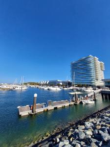 muelle con bancos y barcos en un puerto deportivo en Troia Setubal Praia, en Tróia