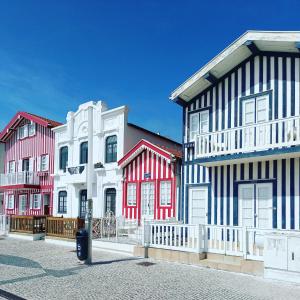 a row of colorful houses on a street at SonhosQrodopiam Praia da Barra in Praia da Barra