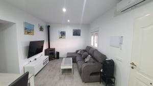 a living room with a couch and a tv at Casa Las Marismas in Barbate