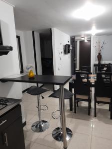 a kitchen and dining room with a table and chairs at Apartamento y Piscina a 3' del Parque del Cafe in Montenegro +8 photos