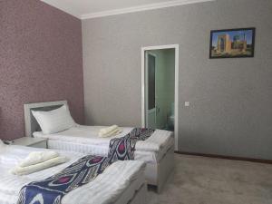 a hotel room with two beds and a mirror at Hotel Han in Samarkand