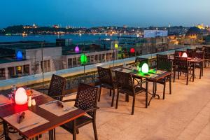 a group of tables and chairs on a roof at Nidya Hotel Galataport in Istanbul