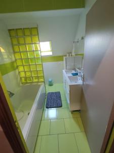 Baño pequeño con bañera y lavamanos en Maison chaleureuse avec netflix et ps5 en Valenciennes