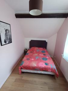 een slaapkamer met een rood bed op zolder bij Maison chaleureuse avec netflix et ps5 in Valenciennes