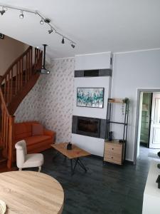 een woonkamer met een bank en een tafel bij Maison chaleureuse avec netflix et ps5 in Valenciennes