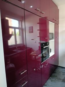 - une cuisine rouge avec une cuisinière et une fenêtre dans l'établissement Maison chaleureuse avec netflix et ps5, à Valenciennes