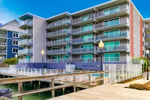 un edificio de apartamentos con un muelle frente a él en Assateague House 205 en Ocean City