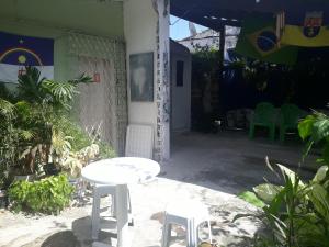 a white table and two stools in front of a building at Casa amora olinda in Olinda