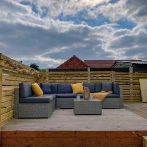 a blue couch sitting on top of a patio at Ruddingwood Lodge in Tuxford