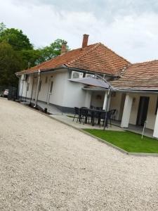 ein Haus mit einem Tisch und Stühlen im Hof in der Unterkunft Csengő Vendégház in Kiskőrös